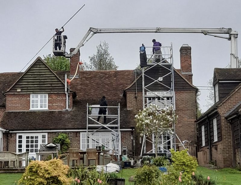 The Moss Cleaners using cherry picker and scaffolding to clean roof safely and professionally in Stratford-upon-Avon, Warwickshire